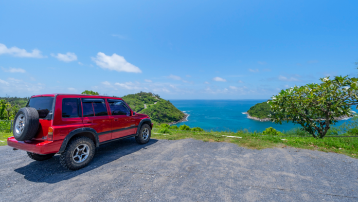 carro vermelho em frente ao mar de férias no litoral